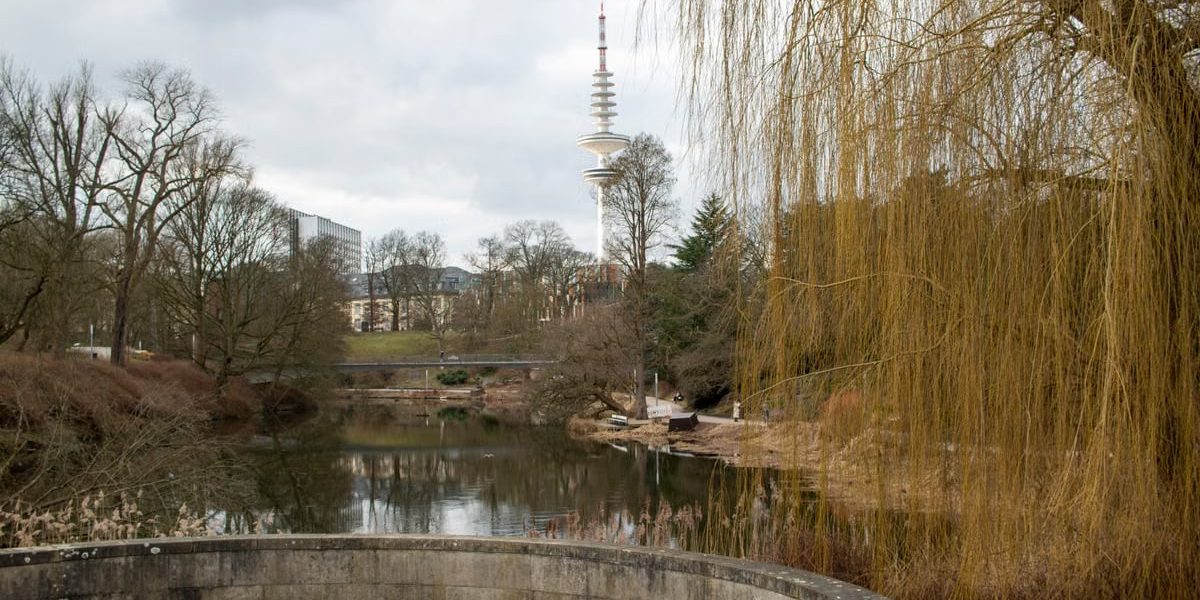 Peaceful landscape of Planten un Blomen Park with view of Fernsehturm in Hamburg, Germany.